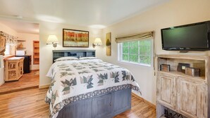 A bedroom with a bed, a television, a window, and a desk with a lamp. - 'Minnehaha' Allenspark Cabin Near Hiking! (Allenspark)