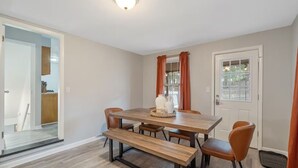 A dining area with a wooden table, four chairs, and a bench. - Hot Tub, Game Room, Near SU, sleeps 10 (Syracuse)