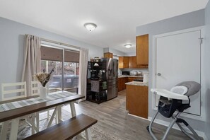 A compact kitchen with a refrigerator, microwave, and wooden cabinets. - Hot Tub, Game Room, Near SU, sleeps 10 (Syracuse)