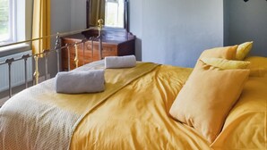 A bedroom with a bed, a dresser, a mirror, and a window with curtains. - 4 bedroom accommodation in Saxmundham (Saxmundham)