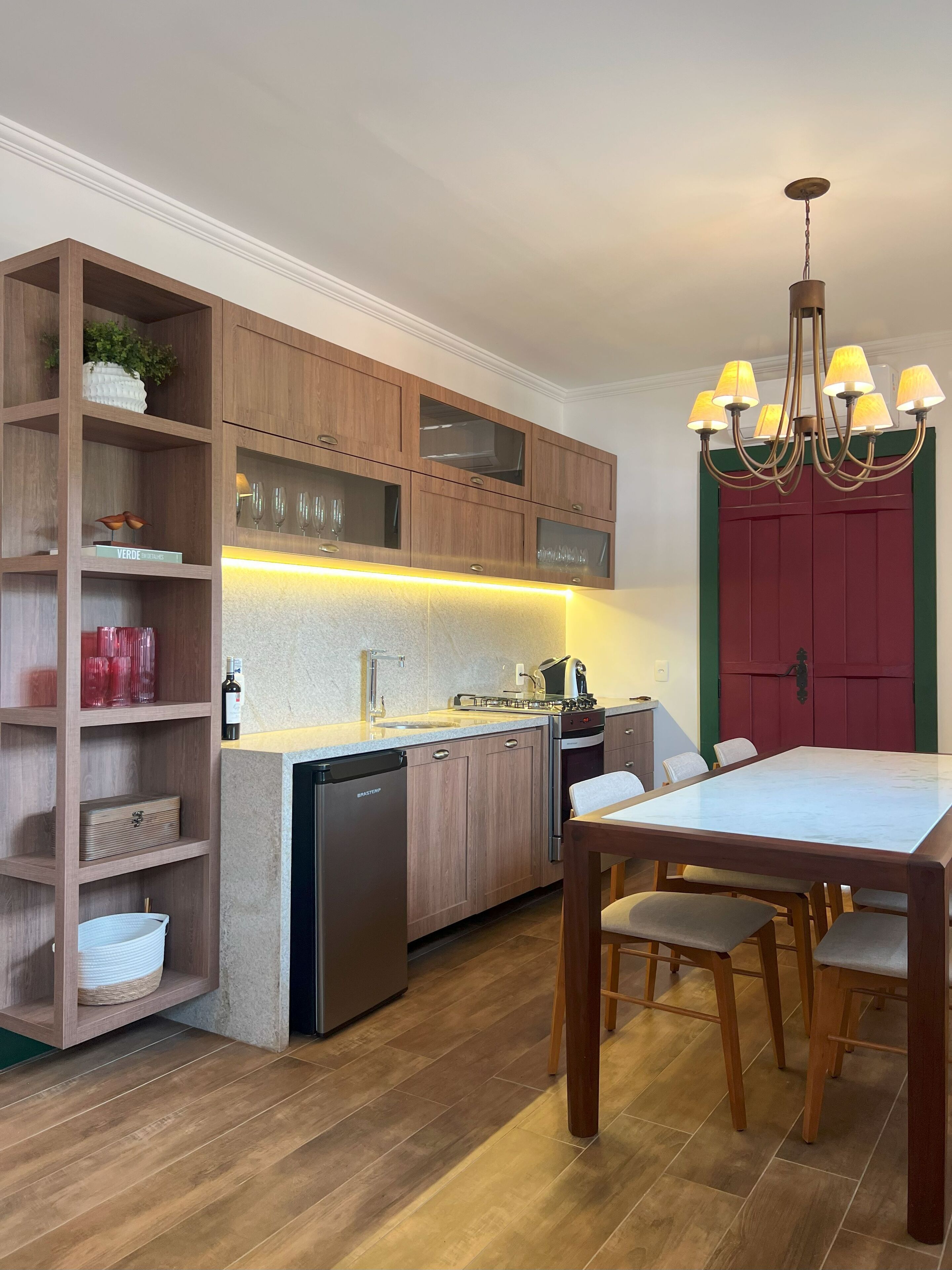 Una cocina moderna con armarios de madera, lavavajillas empotrado y una zona de comedor con mesa y sillas.