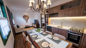 A modern kitchen with a central island, wooden cabinets, and a built-in oven. - Villa Chafariz  (Tiradentes)