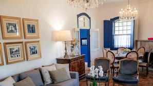 A living room with a sofa, armchairs, a coffee table, and a chandelier. - Villa Chafariz  (Tiradentes)
