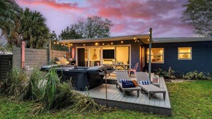 A backyard with a barbecue grill, outdoor seating, and a pool. - Hot Tub, Firepit, Deck | 10mins to Beach | Middle Terrace Cottage by AvantStay (Fort Lauderdale)