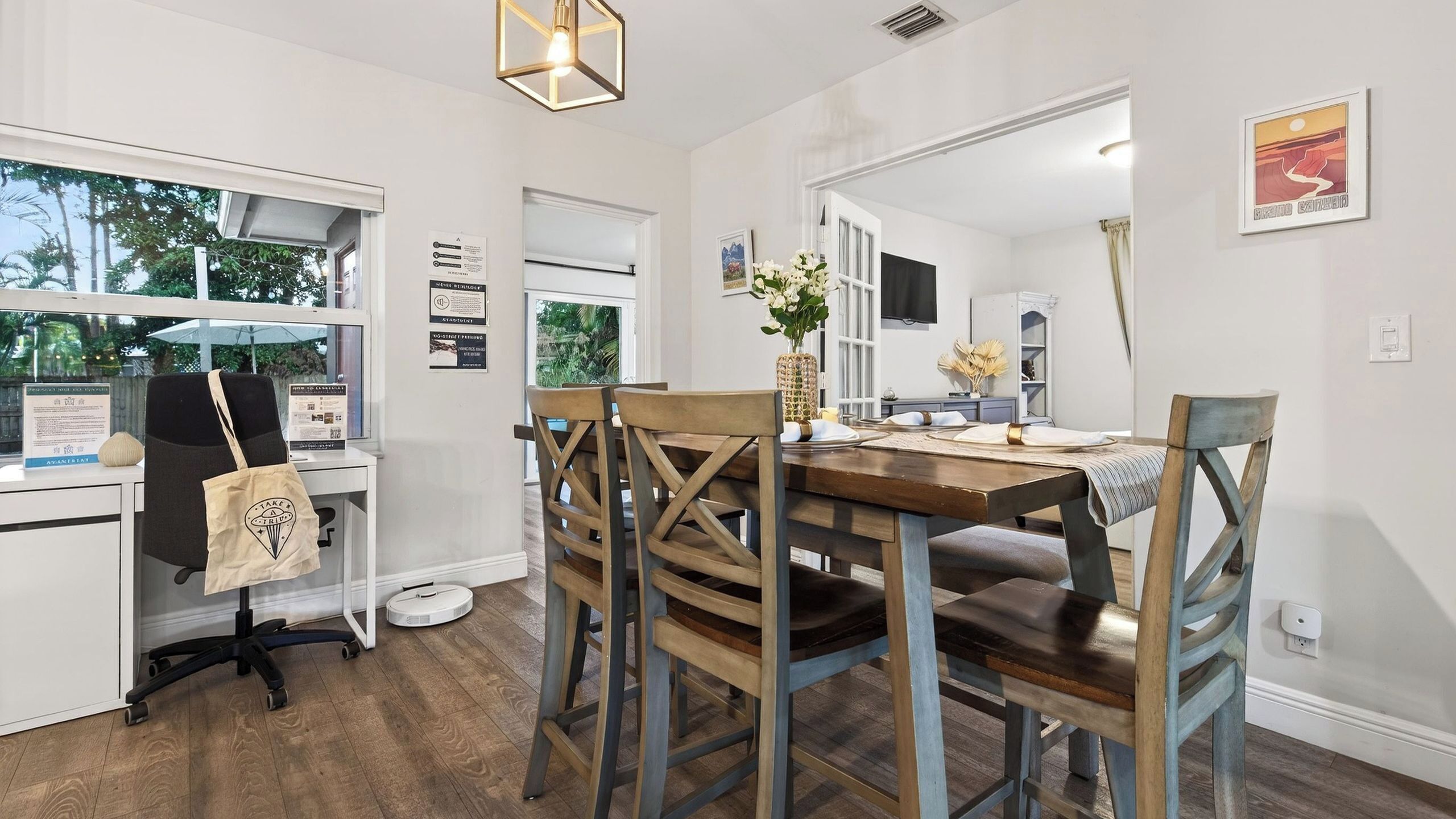 Un comedor con una mesa de madera, sillas y vistas al exterior.