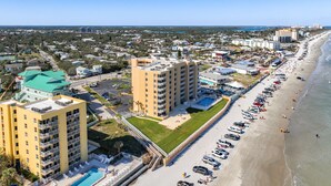 A coastal hotel with multiple floors, a swimming pool, and a beachside location. - Direct Oceanfront Condo - Pool, Beach & Steps from Flagler Ave (New Smyrna Beach)