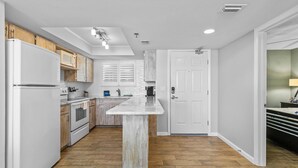 Una cocina con armarios blancos, encimera de madera e isla central.