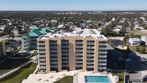 Un hôtel de grande hauteur doté de nombreux balcons, d’une piscine et d’une pelouse bien entretenue.