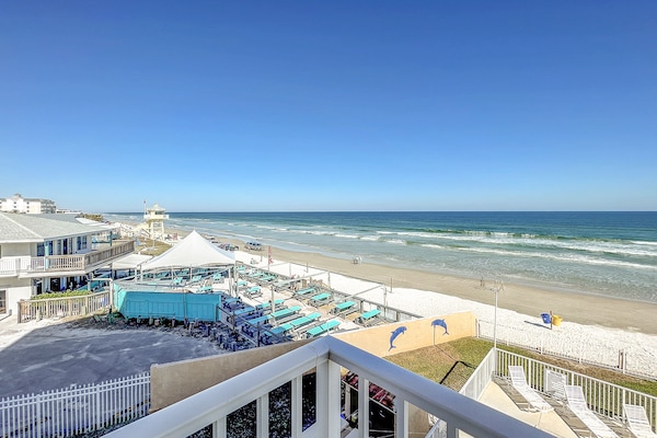 Relax by the shore with stunning ocean views, turquoise lounge chairs, and the calming sound of waves in this perfect beachfront retreat.