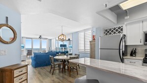 A modern kitchen with white cabinets, a marble countertop, and a built-in refrigerator. - Updated Oceanfront Condo!  Pool, Beach & steps from Flagler Ave (New Smyrna Beach)