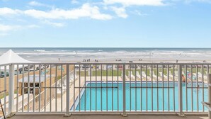 A pool area with a view of the beach and ocean. - OceanFront Condo - Pool, BBQ, Steps from Flagler Ave (New Smyrna Beach)