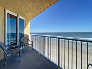 Ein Balkon mit Korbstühlen und Blick auf den Ozean.
