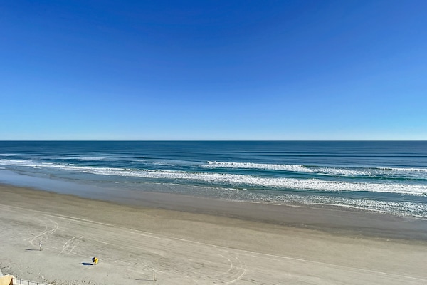Enjoy the calming views of the expansive blue ocean meeting the horizon under clear skies.