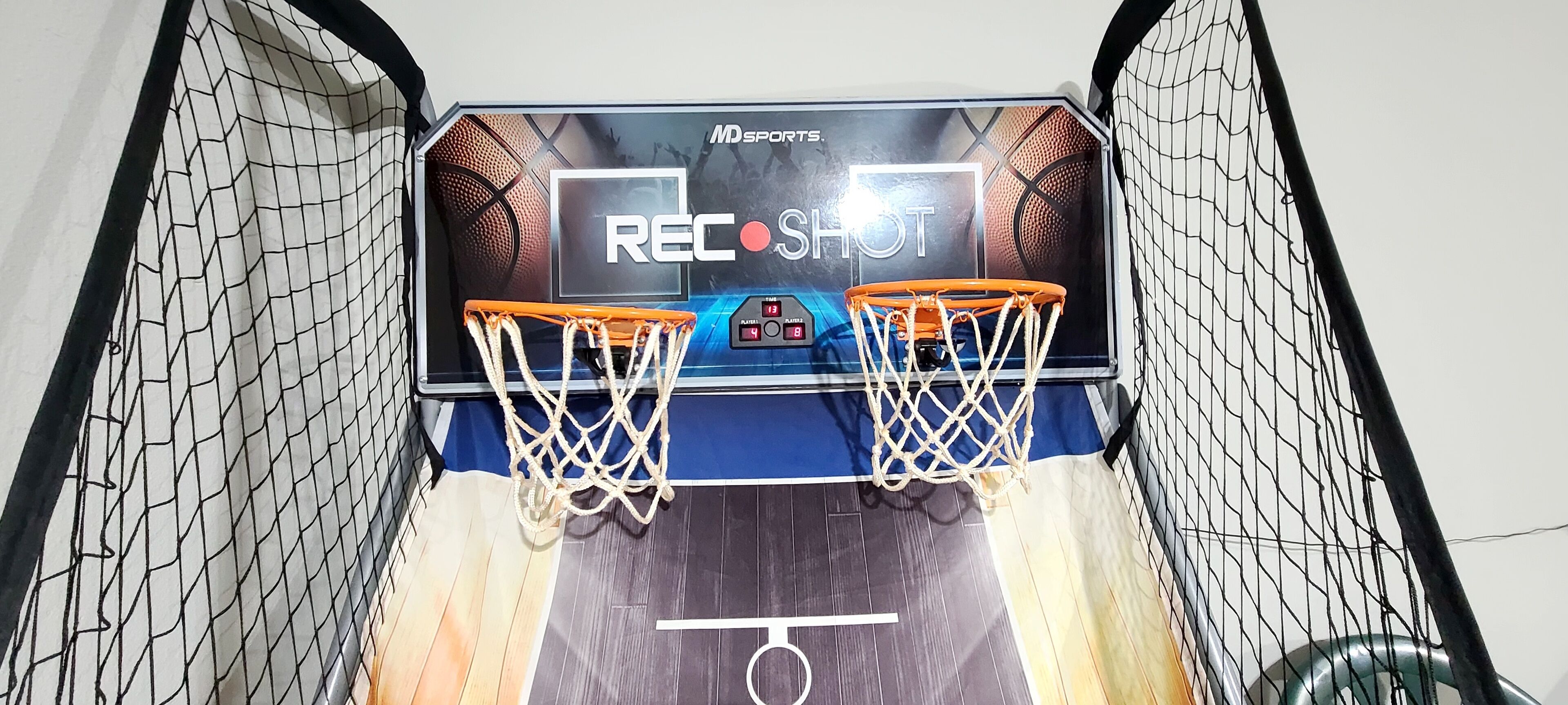 Una cancha de baloncesto con dos aros y un marcador.