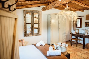 A rustic room with a wooden bed, a large wardrobe, a desk with a chair, and a hanging light fixture. - RANCH CAMPO (Porto-Vecchio)