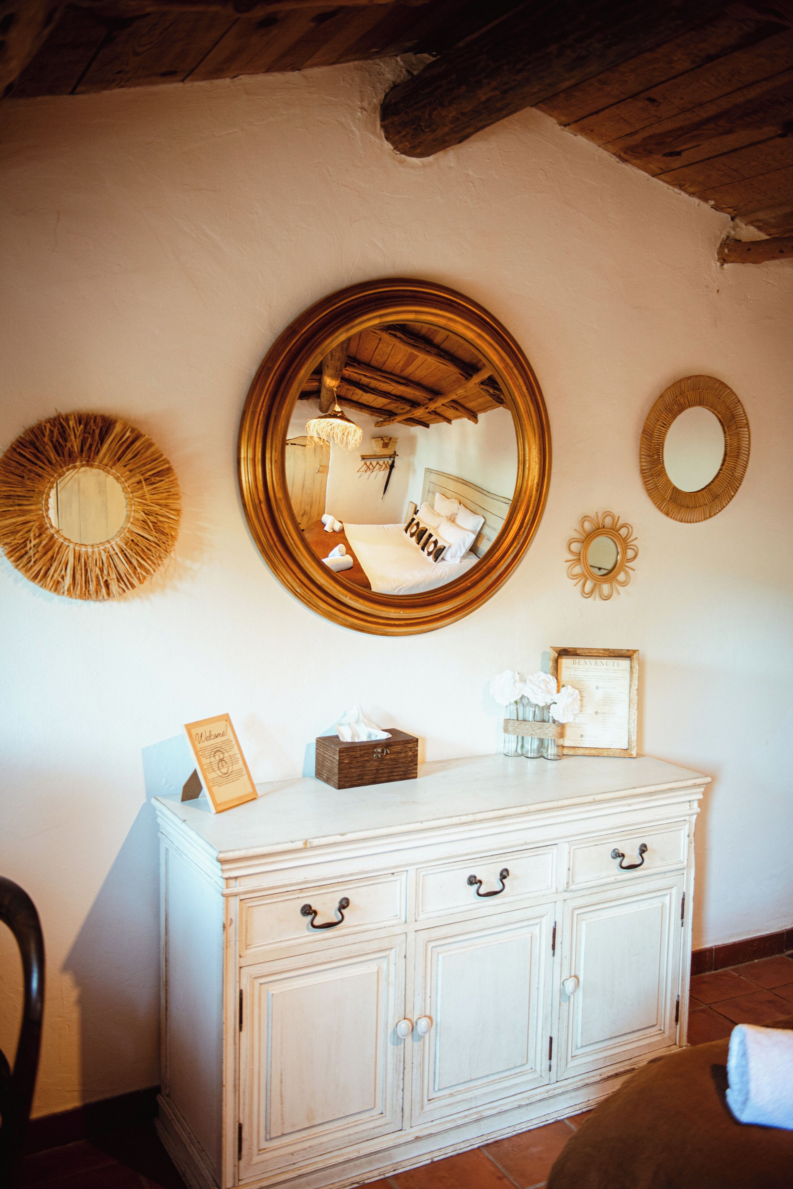 A white dresser with multiple drawers and a mirror above it.