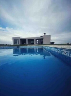 Guests can enjoy a refreshing swim in the pool surrounded by a tiled deck.