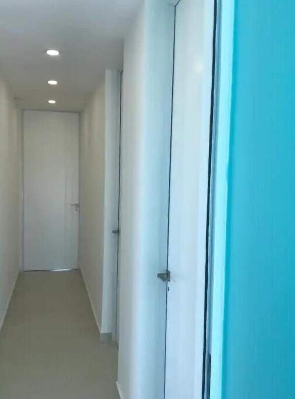 Guest rooms feature narrow hallways with doors and a plain wall.