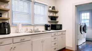 Una cuina compacta amb un rentaplat, microones, cafetera i prestatges integrats.