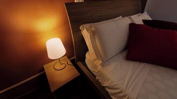 Un letto ben rifatto con cuscini bianchi e rossi, un comodino in legno con una lampada e una testiera in legno.