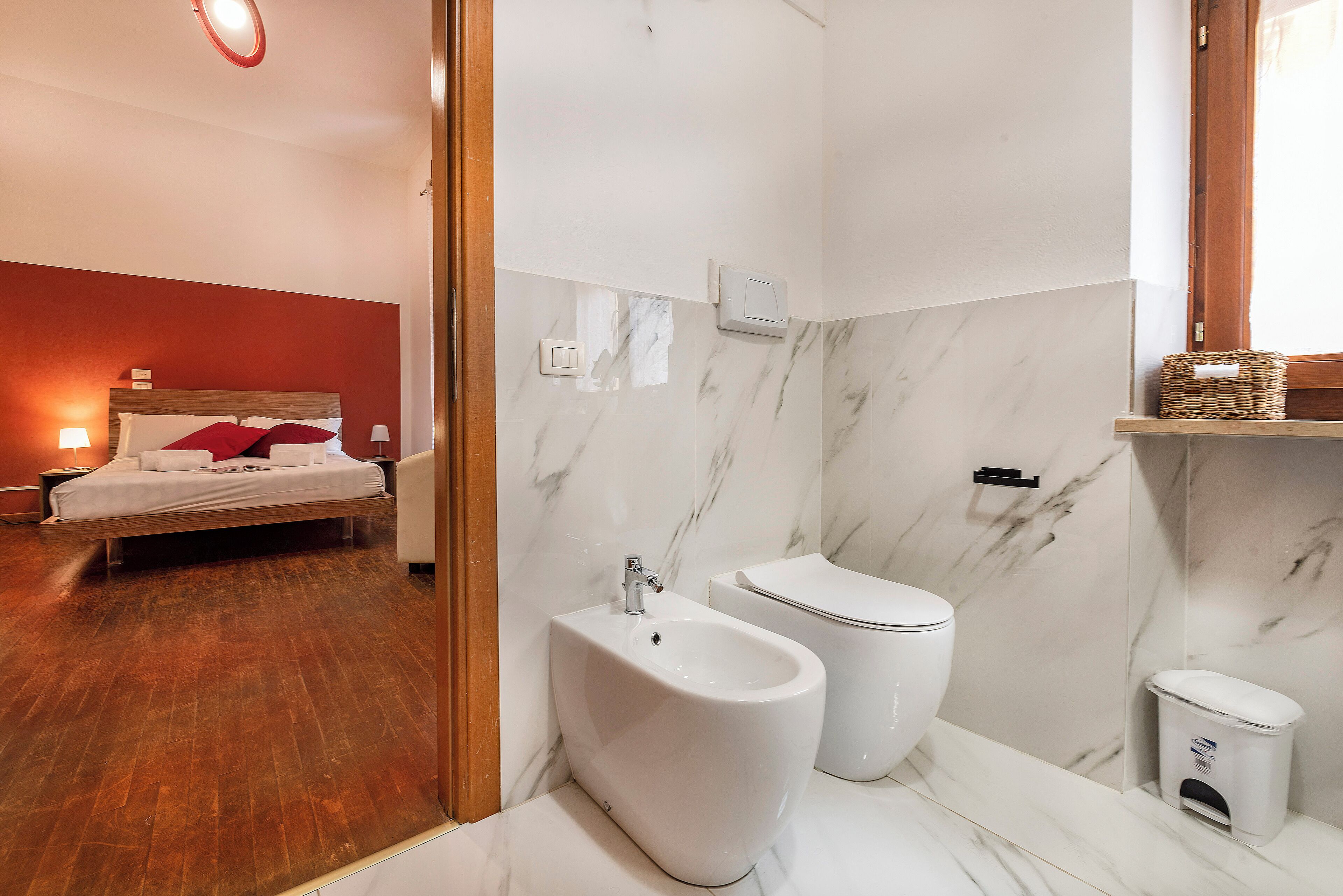 A modern bathroom with a bidet, toilet, and marble walls.