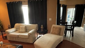 A living room with a beige sofa, a matching armchair, a small table, and a glass coffee table. - Rare & Amazing 3 bdrm 2 bath apt with pool gives you a home away from home feel. (Lutz)