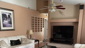 A living room with a white sofa, a glass coffee table, and a fireplace. - Rare & Amazing 3 bdrm 2 bath apt with pool gives you a home away from home feel. (Lutz)