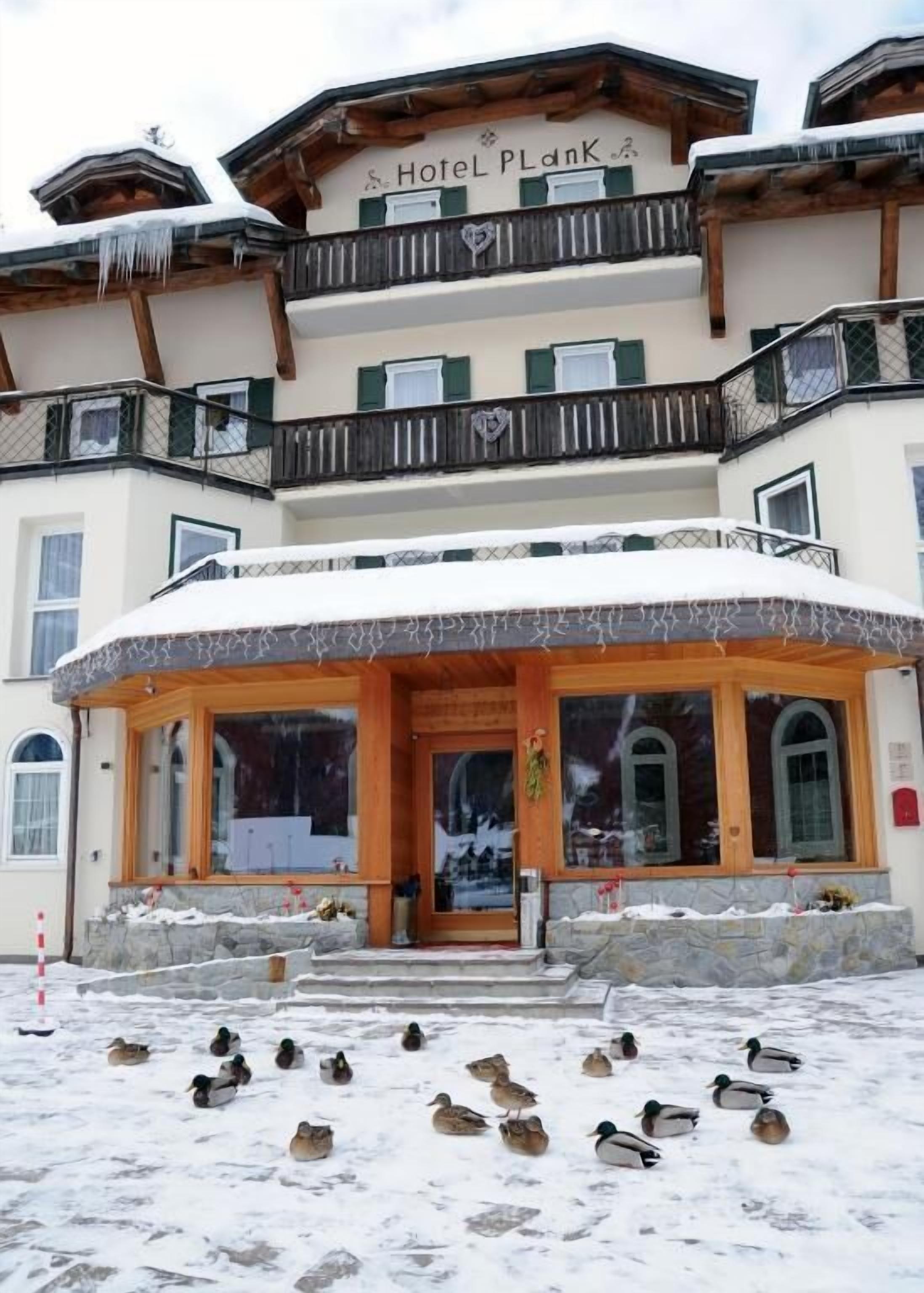 Ein Hotel mit einem Schild, auf dem 'Hotel PlanK' steht, und einem verschneiten Eingang.