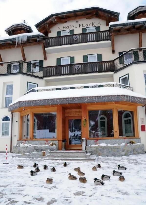 A hotel with a sign reading "Hotel PlanK" and a snow-covered entrance. - Hotel Plank (Primiero San Martino di Castrozza)