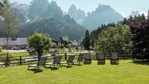 Un espace verdoyant avec des sièges en plein air et une vue sur les montagnes en arrière-plan.