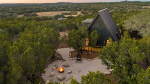Un bâtiment moderne doté d’un toit triangulaire, entouré d’une végétation luxuriante.