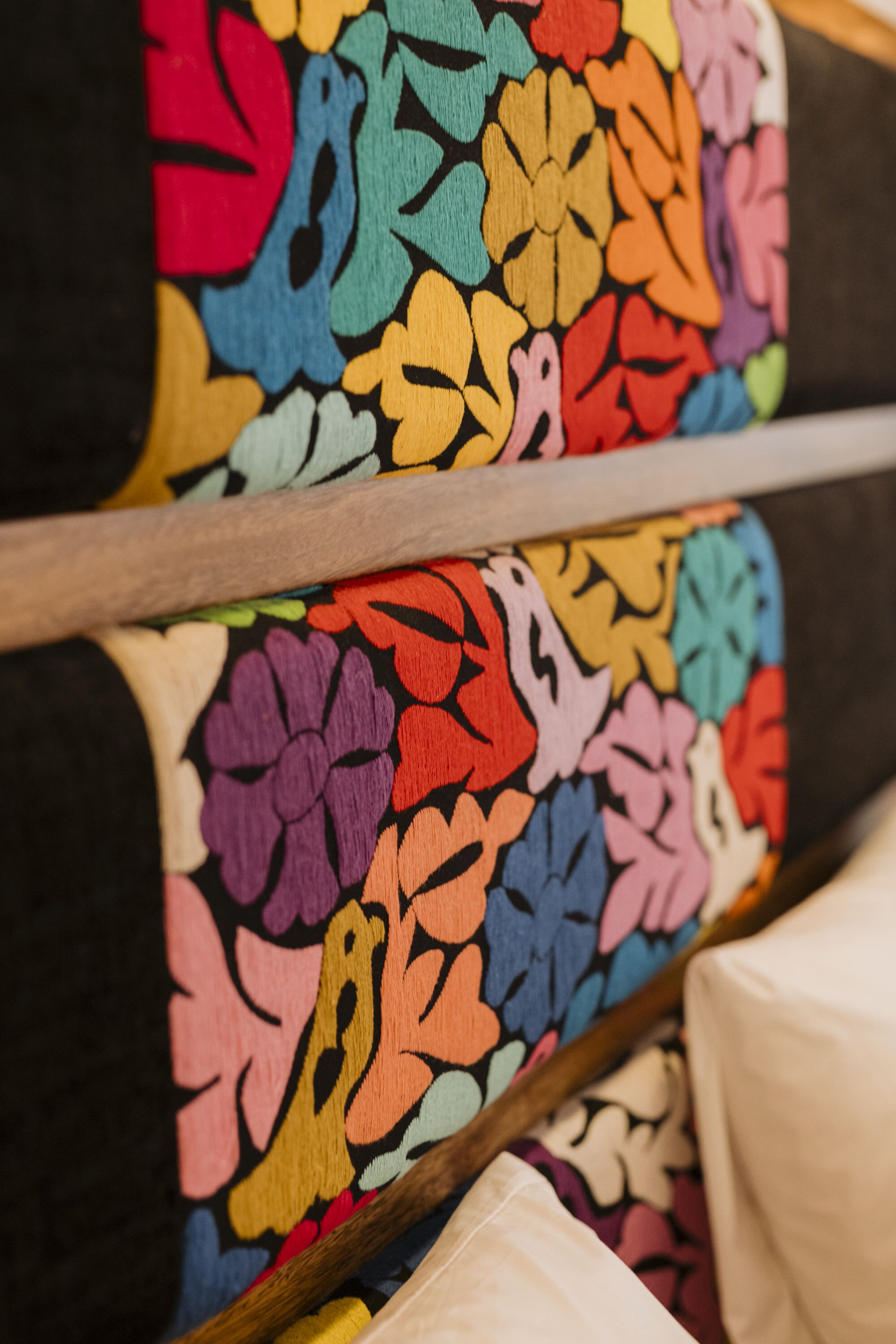 A close-up of a colorful, patterned fabric, likely part of a piece of furniture or decor.