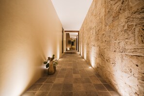 A narrow hallway with a tiled floor and a plant on the left. - PUNTA AGAVE SUITES (Oaxaca)