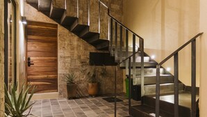 Un escalier moderne avec des rampes en métal menant à une porte en bois.