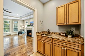 Una cocina moderna con armarios de madera, encimera de granito y chimenea.