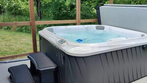 Ett bubbelbad med ett trädäck och en bänk.