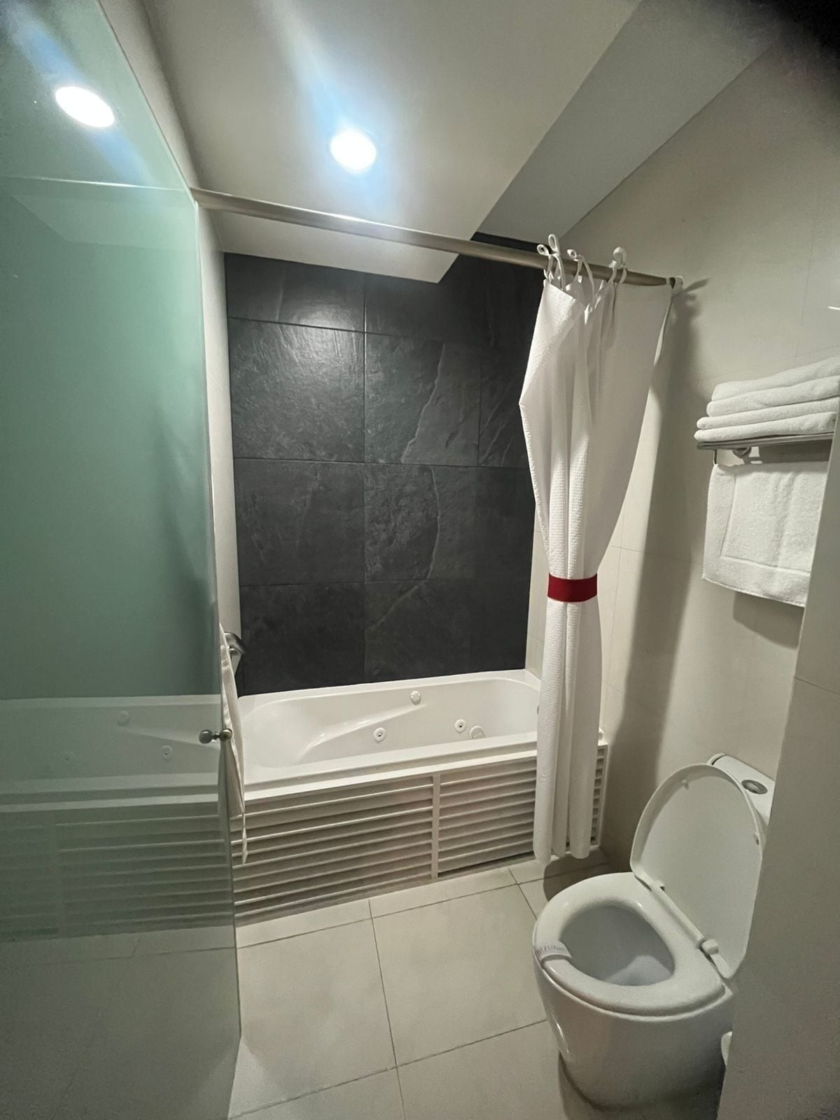 Un baño moderno con bañera, inodoro y cortina de ducha.