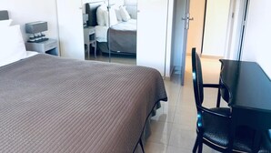 Een hotelkamer met een bed, een bureau en een stoel.