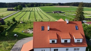 Un grand bâtiment blanc avec un toit rouge, de nombreuses fenêtres et une allée pavée.