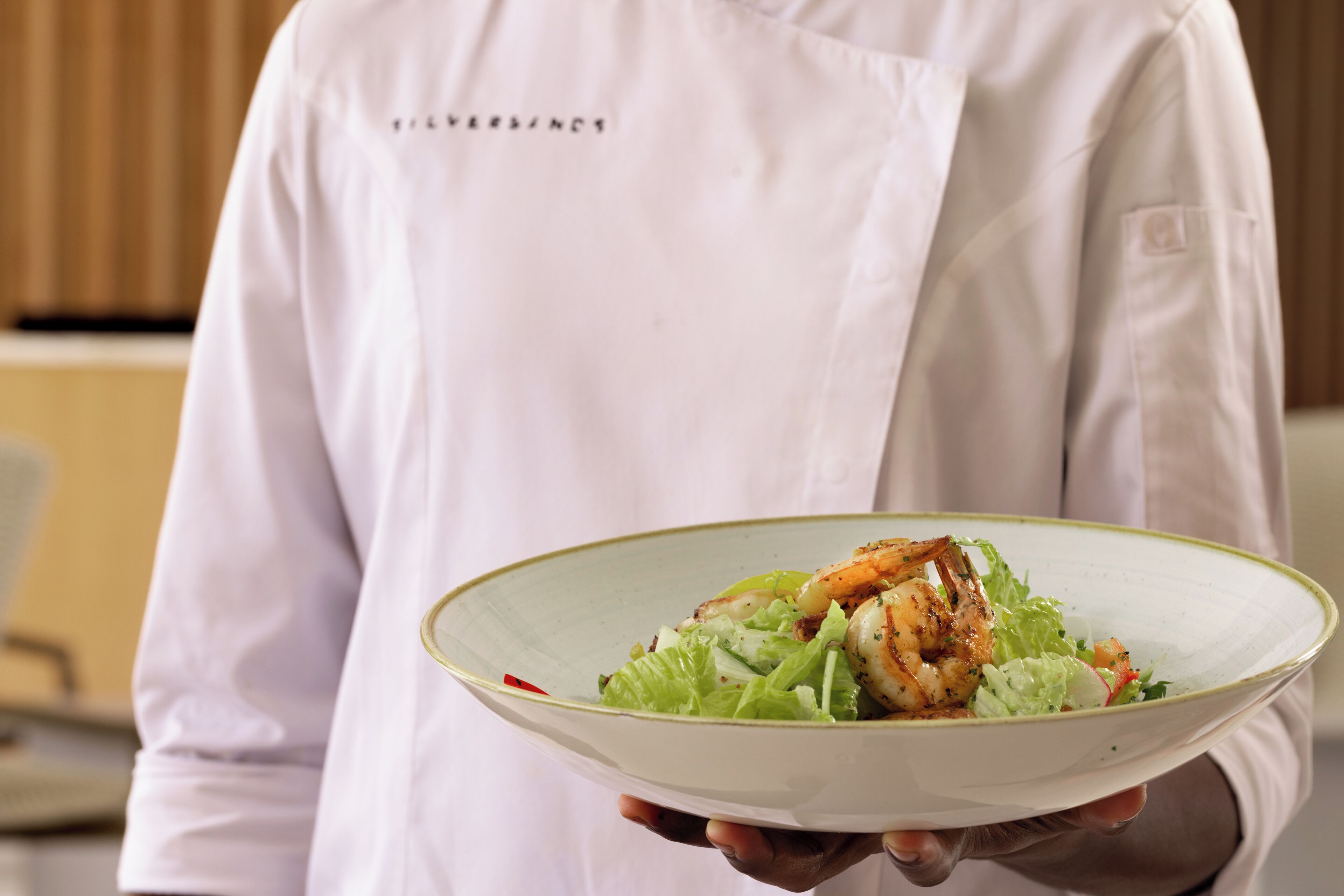 Un chef tenant une assiette de nourriture.