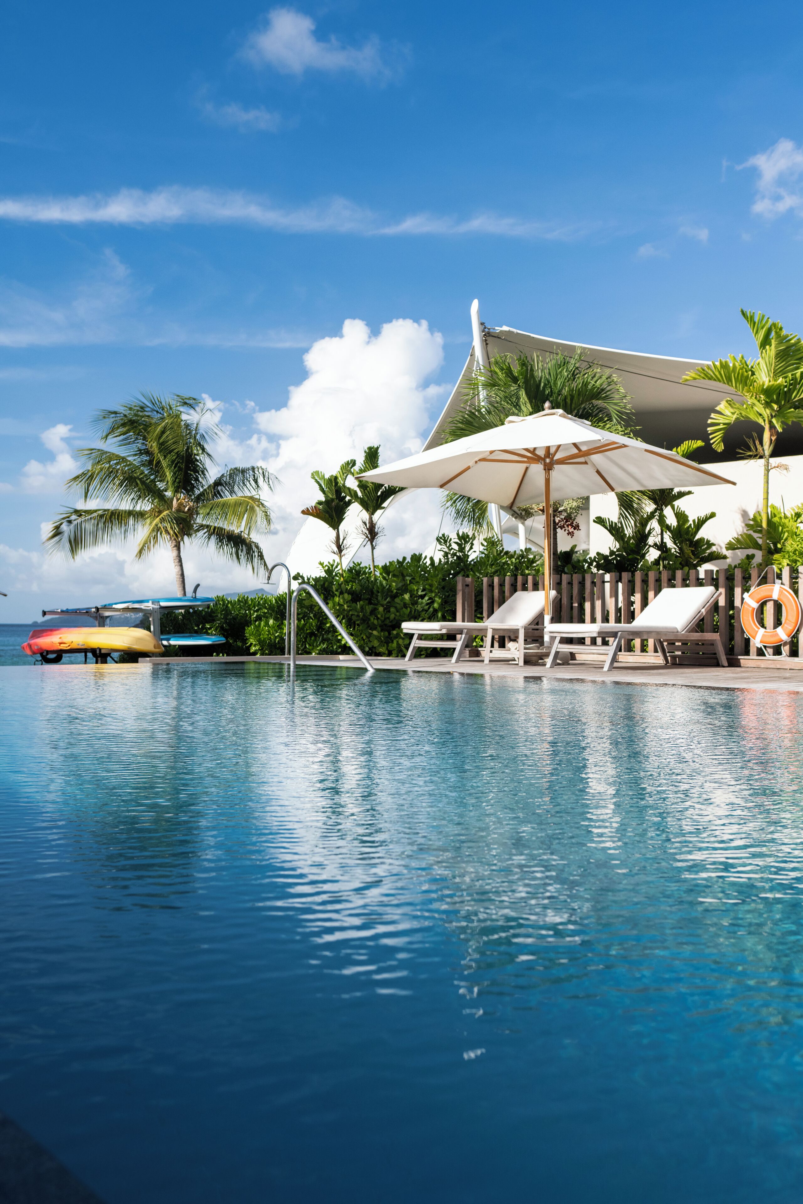 室外游泳池，池畔遮阳伞，日光浴躺椅