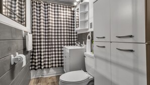 Un baño pequeño con inodoro, lavamanos y mueble.