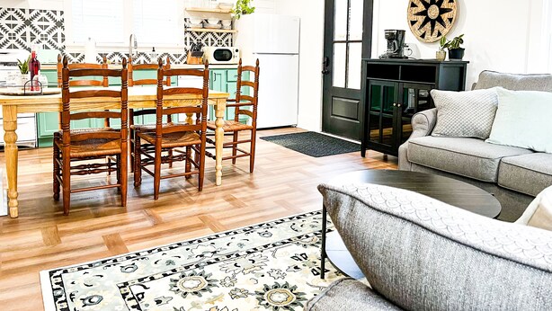 A modern kitchen with wooden chairs, a dining table, and a black cabinet. - Cozy Colonial in Downtown Westfield, NY (Westfield)
