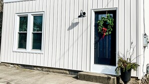 A two-story house with a front door, a small porch, and a window with a wreath. - Cozy Colonial in Downtown Westfield, NY (Westfield)