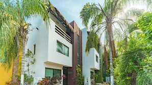 A modern two-story building with a white facade, large windows, and a central entrance. - Tranquilidad 3 Bedroom Home At El Cielo (Playa del Carmen)