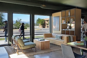 Una sala de estar moderna con sofá, sillón, mesa de centro y estantería.