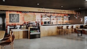 Eine moderne Bar mit einer Holztheke, Barhocker und einer Speisekarte.