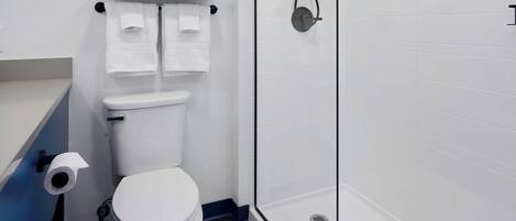 Ein modernes Badezimmer mit Toilette, Duschkabine und Handtuchhalter.