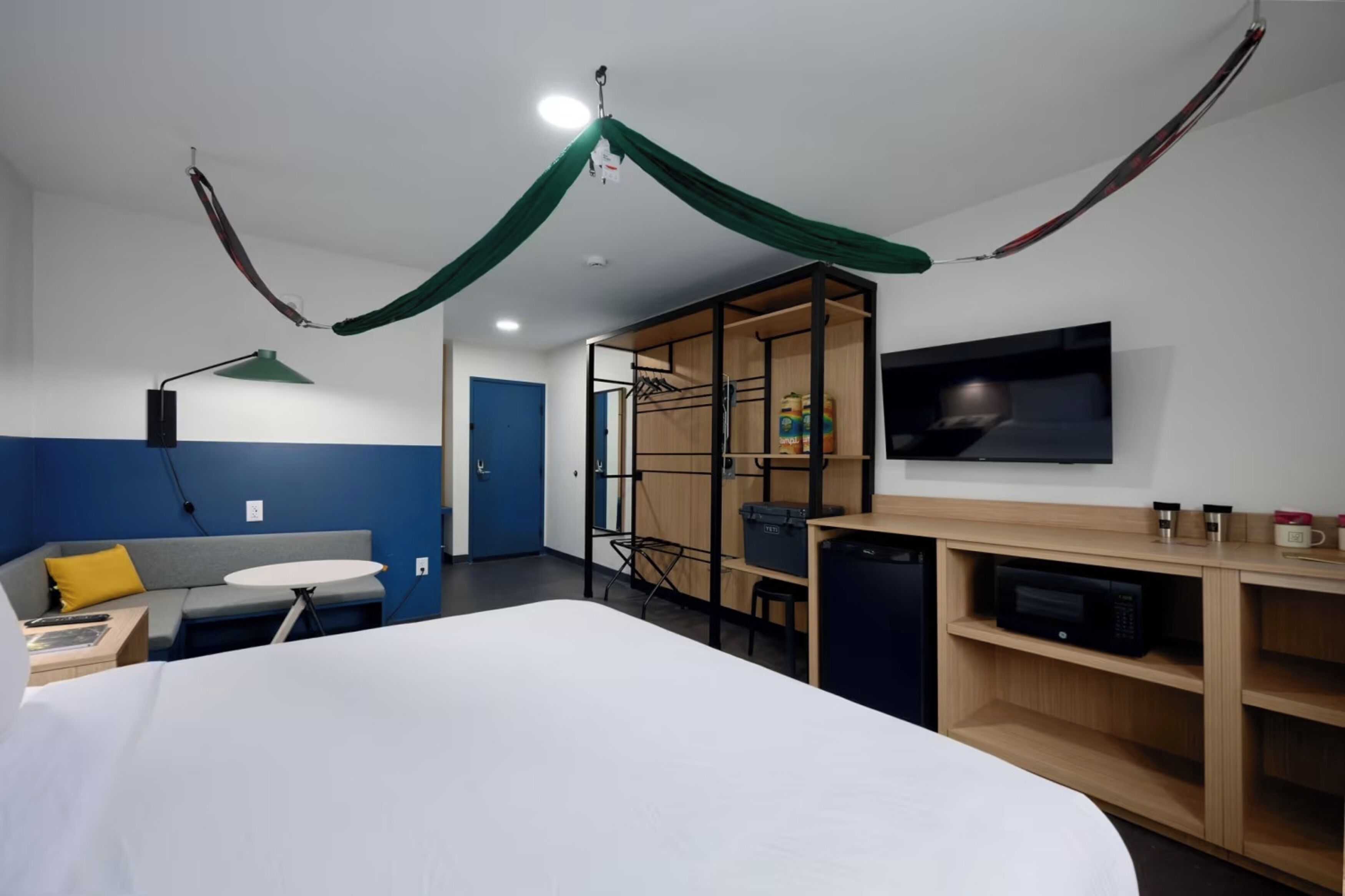 A hotel room with a bed, a desk, a TV, a microwave, and a wardrobe.