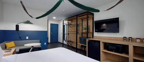 A hotel room with a bed, a desk, a TV, a microwave, and a wardrobe.